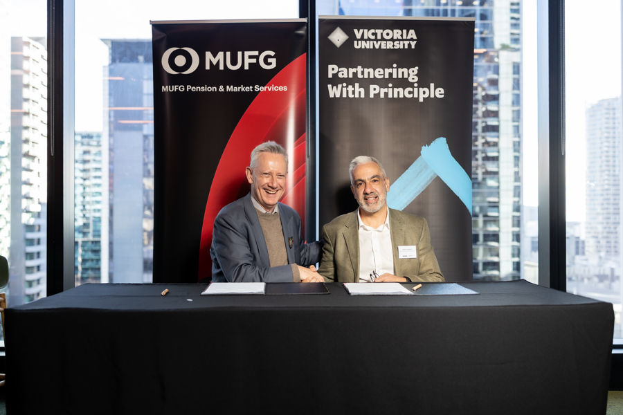 Adam Shoemaker, Vice-Chancellor of Victoria University, and Frank Lombardo, CEO of MUFG Retirement Solutions ANZ, shake hands at a partnership signing.